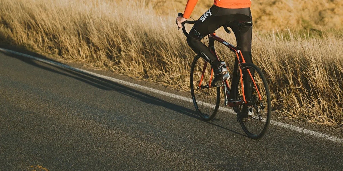 Cyklist i cykelbyxor trampar på landsväg i solljus
