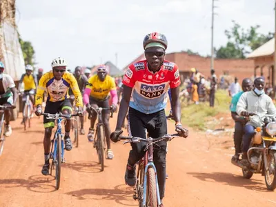 Cyklister på dammig väg i Afrika