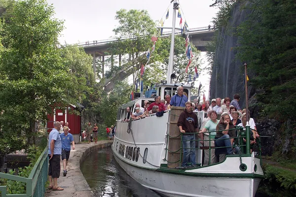 Passagerarbåt i smal kanal under hög bro, Dalslands kanal