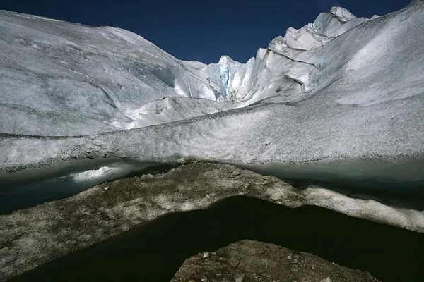 Glaciärlandskap med isformationer och smältvattenpool