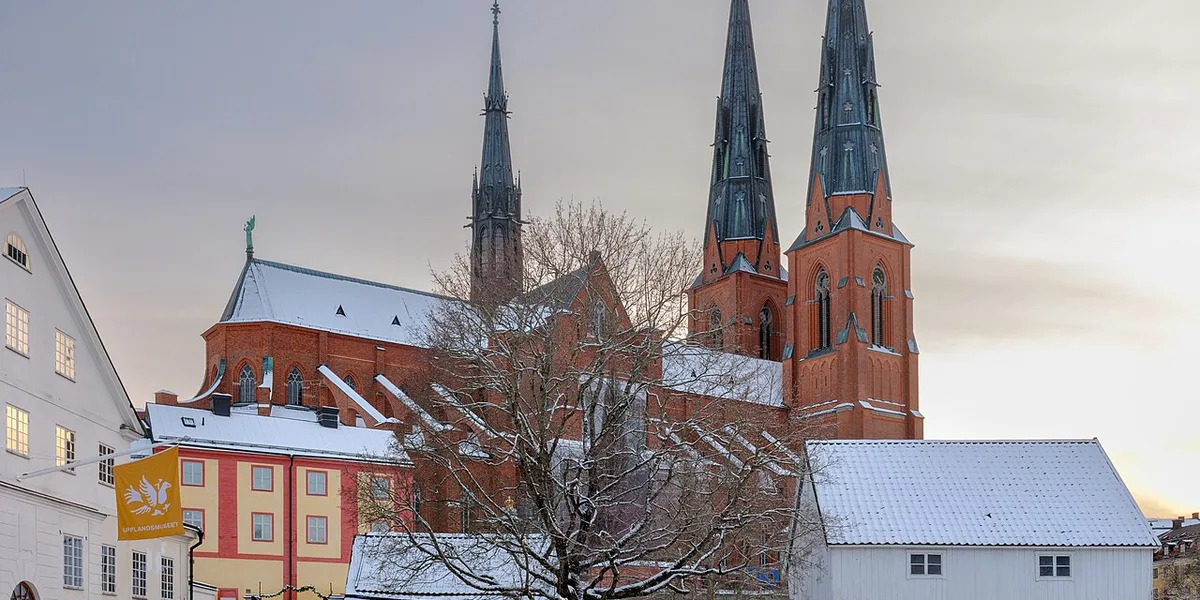 Uppsala domkyrka i vinterskrud sedd från Kvarnfallet med snötäckta tak
