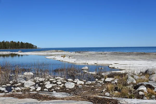 Stenig kust med klipphällar och blått vatten vid Vättern