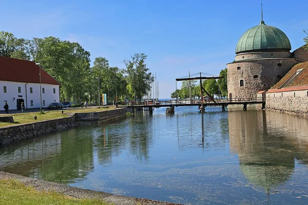 Vadstena slott med sitt karaktäristiska rundtorn och vallgrav i sommarskrud